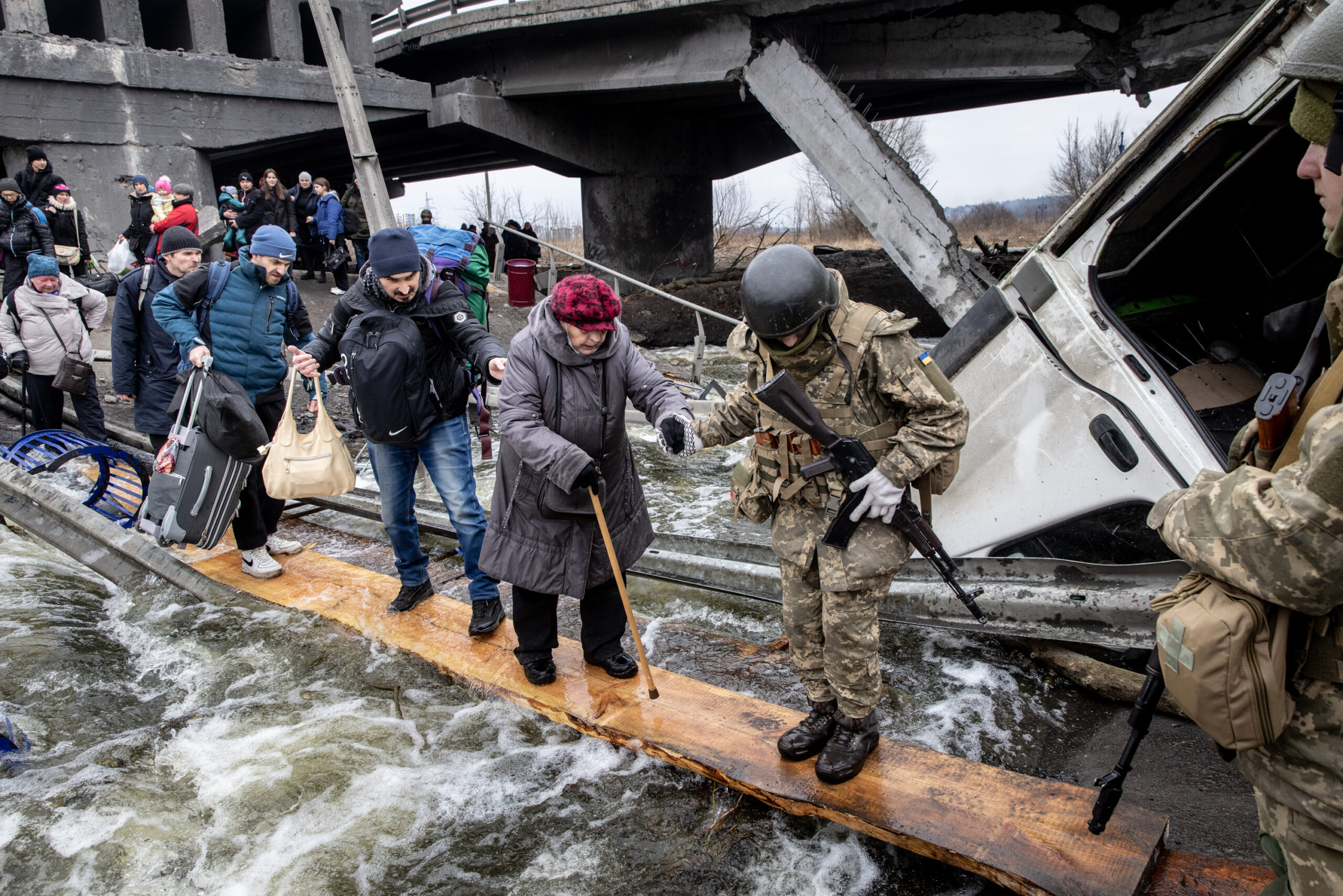 Civilians being helped across a river by soldiers from the Ukraine Army